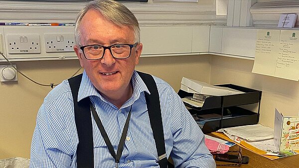 Jamie Stone pictured at a desk with papers